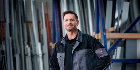 Ein Mann in Arbeitskleidung steht in einer Halle